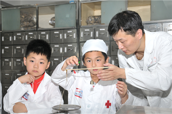 奚吉湘在手把手教孩子们用戥秤.jpg